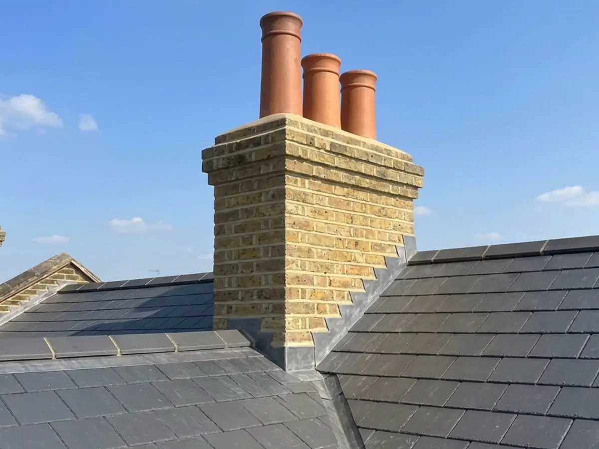 Repointed stock brick chimney stack with clay pots and new lead flashing